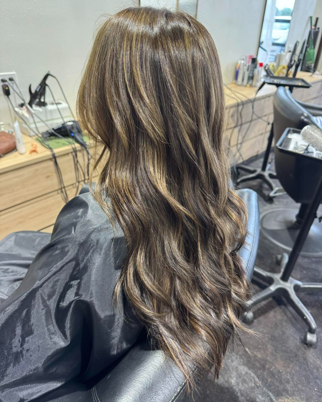 Rich brunette with caramel dimensional highlights and soft waves